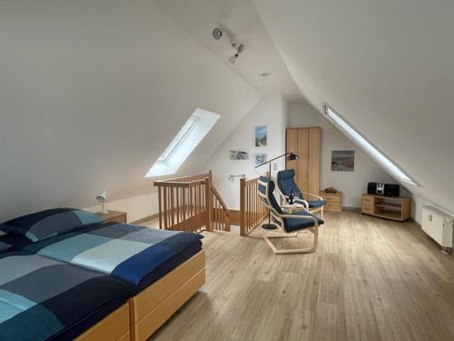 1 dormitorio con 1 cama y 2 sillas en el ático en Birkenstr_ 6 Wohnung 6, en Zingst