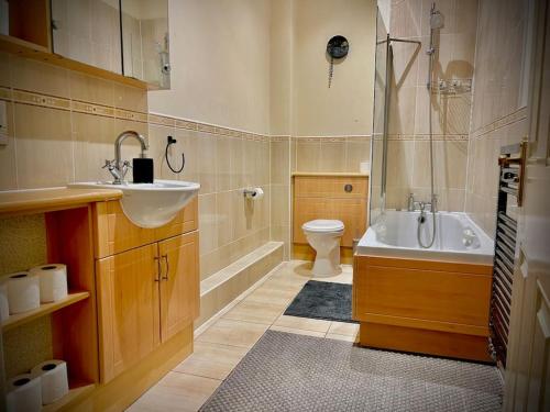 a bathroom with a sink and a tub and a toilet at 5 Bedroom House-Sleeps 13-Big Savings On Long Stays! in Colchester