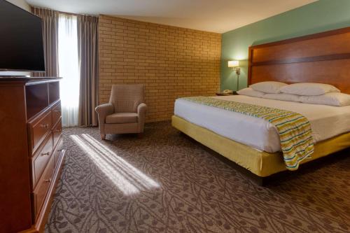 Drury Inn & Suites Atlanta Morrow في مورو: غرفه فندقيه سرير وتلفزيون