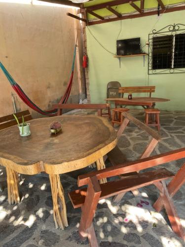 a group of tables and benches in a room at Hotel Pacific Surf Tunco Beach best Room Surf City in La Libertad