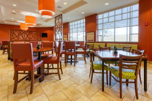 a restaurant with wooden tables and chairs and windows at Drury Inn & Suites Indianapolis Northeast in Indianapolis