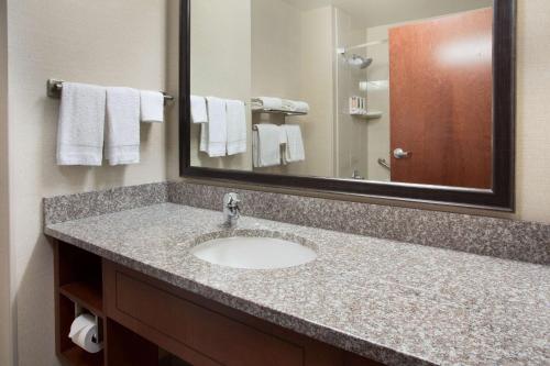 a bathroom with a sink and a mirror and towels at Drury Inn & Suites Mt. Vernon in Mount Vernon