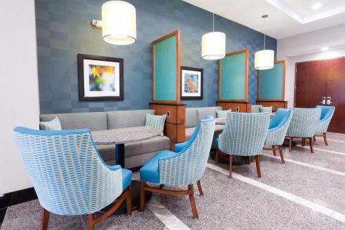 a waiting room with blue chairs and a table at Drury Inn & Suites Burlington in Burlington