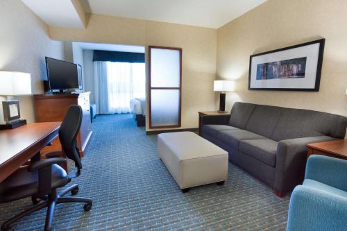 a hotel room with a couch and a desk at Drury Inn & Suites Burlington in Burlington
