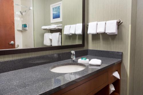 a bathroom with a sink and a mirror and towels at Drury Inn & Suites Burlington in Burlington