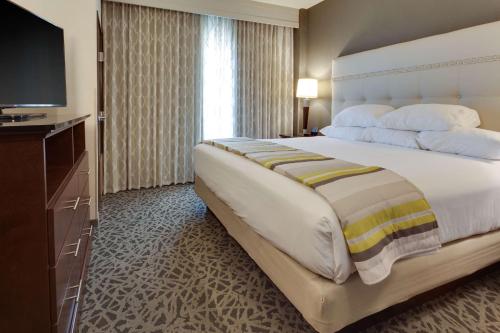 a bedroom with a large bed with a flat screen tv at Drury Plaza Hotel Cape Girardeau Conference Center in Cape Girardeau