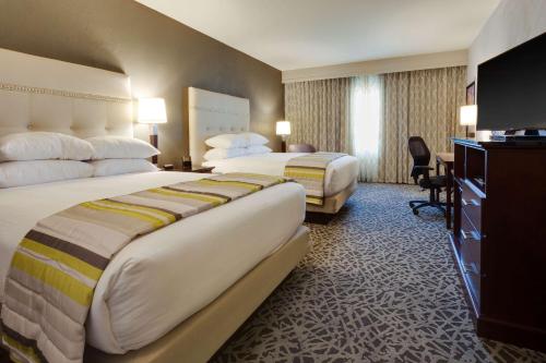a hotel room with two beds and a desk at Drury Plaza Hotel Cape Girardeau Conference Center in Cape Girardeau
