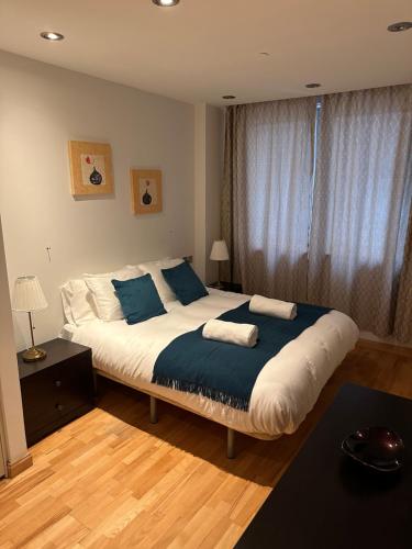 um quarto com uma cama grande e almofadas azuis em Britain in the Sun at Luxurious Ocean Village em Gibraltar