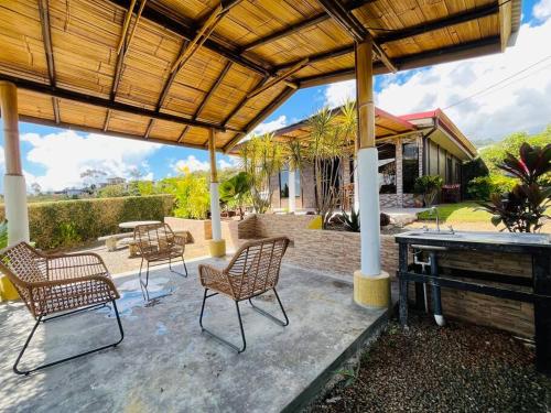 eine Terrasse mit Stühlen, einem Tisch und einem Grill in der Unterkunft Casa Bambohemia in Miravalles