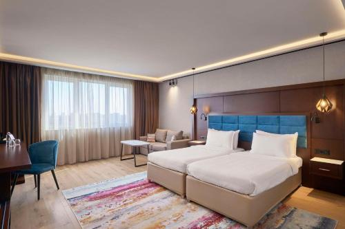 um quarto de hotel com uma cama grande e uma secretária em Hotel Imperial Plovdiv, a member of Radisson Individuals em Plovdiv