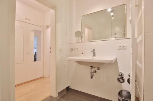 a white bathroom with a sink and a mirror at Haus Hubertus Haus Hubertus Appartement 05 in Niendorf