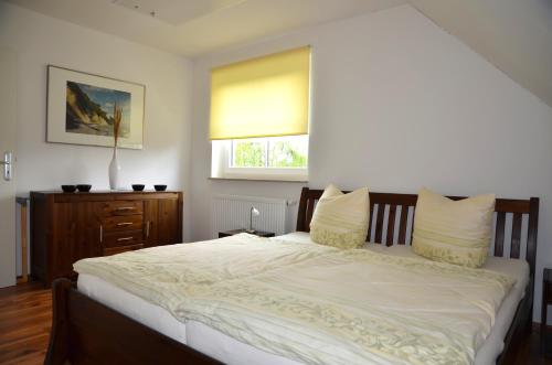 Un dormitorio con una gran cama blanca con ventana. en Ferienhaus Lütt Eiland, en Polchow