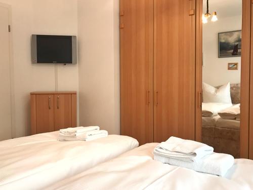 ザスニッツにあるMeerblickvilla Prinz Heinrich - Ferienwohnung 4のベッド2台とテレビが備わるホテルルームです。