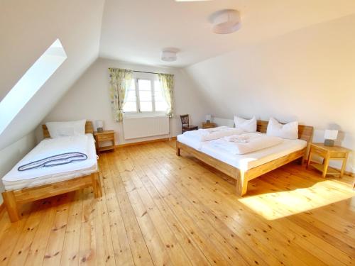Schlafzimmer im Dachgeschoss mit 2 Betten und einem Fenster in der Unterkunft Hofgut Bisdamitz - Ferienhaus "Alte Mühle" in Bisdamitz