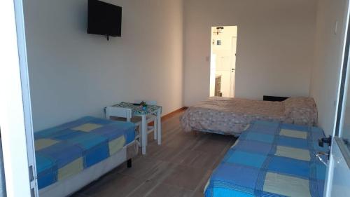 a small room with two beds and a television at ABBA Departamento Turístico 3 in Trevelin