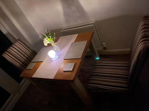 a wooden table with a vase of flowers on it at Room near Teesside University in Middlesbrough