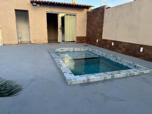 a swimming pool in front of a house at Cantinho da Alegria in Raul Soares