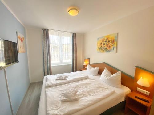 1 dormitorio con cama blanca y ventana en Ferienwohnung 10 "Bootsmann Hannes", en Wiek auf Rügen