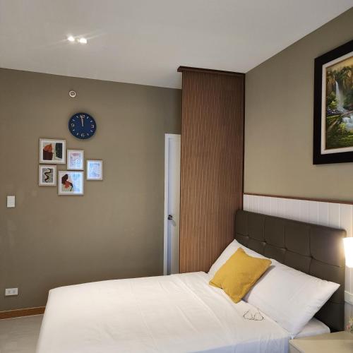 um quarto com uma cama e um relógio na parede em Twin Hearts 328 em Roxas City