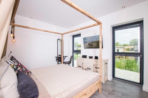 a bedroom with a bed and a large window at _ERL41_ PIER 41 in Niendorf