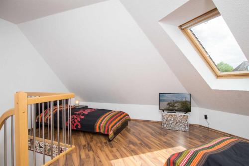 a attic bedroom with a bed and a television at _OST18_ _ Ferienwohnung Muschelsuc in Niendorf