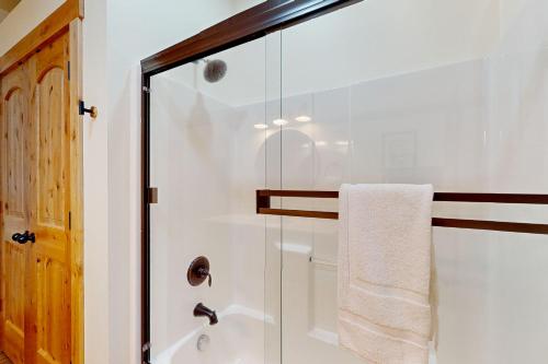 uma casa de banho com um chuveiro e uma toalha branca em Creekside Cabin em Rhododendron