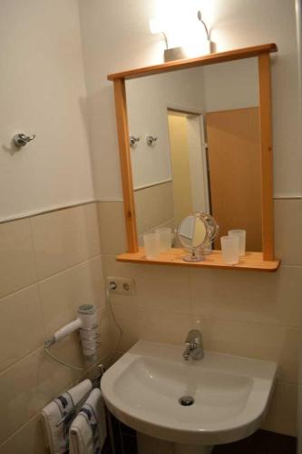 a bathroom with a sink and a mirror at _DKK1d_ Ferienwohnung Seemoewe in Niendorf