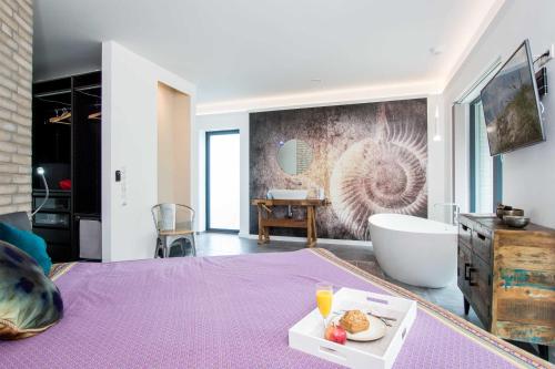 La salle de bains est pourvue d'un lit violet et d'une baignoire. dans l'établissement _ERL43_ PIER 43, à Niendorf