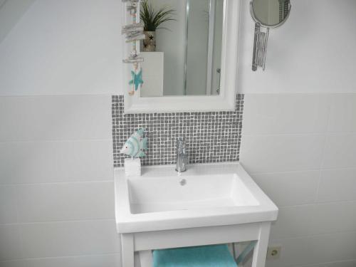 ein Badezimmer mit einem weißen Waschbecken und einem Spiegel in der Unterkunft (WIK7a) in Niendorf