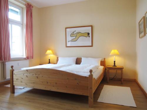 キュールングスボルンにあるFerienwohnung Am Molli Nr. 4のベッドルーム1室(大型木製ベッド1台、ランプ2つ付)