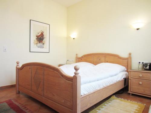 a bedroom with a wooden bed and a wooden dresser at Ferienwohnung Dünenstraße in Kühlungsborn