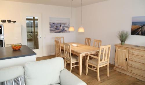 Il comprend une cuisine et une salle à manger avec une table et des chaises en bois. dans l'établissement Ferienwohnung Sonnenblick, à Wittenbeck