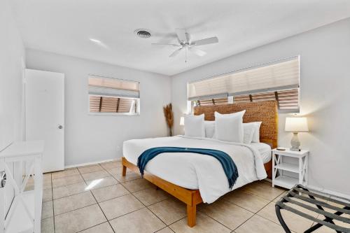 una camera bianca con letto e ventilatore a soffitto di Citrus Isles Waterfront Home a Fort Lauderdale