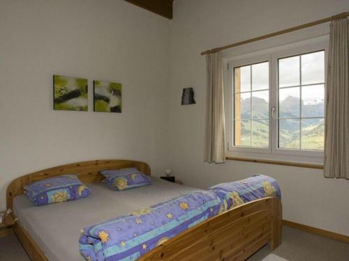 a bedroom with a wooden bed with a window at in the Ella Storta house in Surcuolm