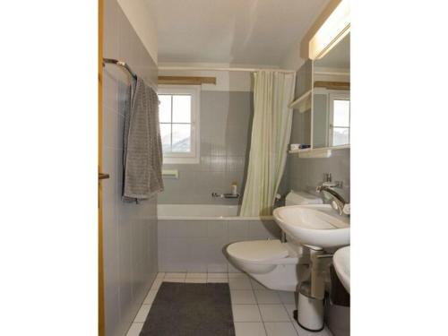 a bathroom with a sink and a toilet and a tub at in the Ella Storta house in Surcuolm