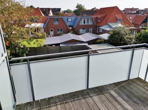 a white privacy fence on a balcony with houses at StrandinSicht in Norderney