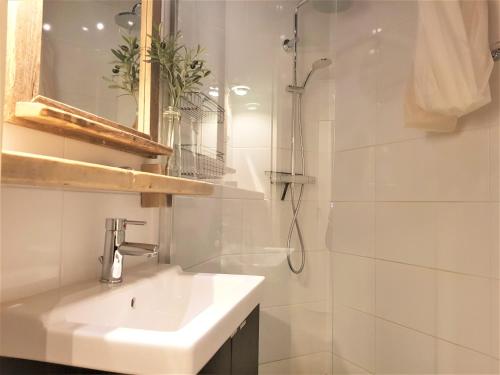 y baño blanco con lavabo y ducha. en Chalet Jägerstieg, en Braunlage