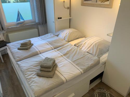 ein Bett mit Handtüchern in einem Zimmer mit Fenster in der Unterkunft Ferienwohnung "Aloki" in Sankt Peter-Ording