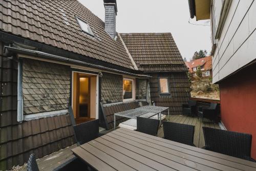 a patio with a table and chairs on a deck at HarzLodge Emma in Braunlage
