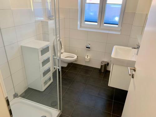 een badkamer met een toilet, een wastafel en een douche bij Ferienwohnung "Strandläufer 1" in Sankt Peter-Ording