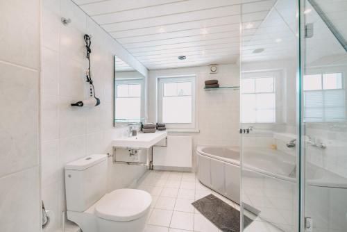 ブラウンラーゲにあるVilla Luna Braunlageの白いバスルーム(トイレ、シンク、バスタブ付)