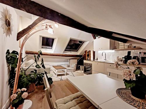 eine Küche und ein Wohnzimmer mit einem Tisch und einigen Pflanzen in der Unterkunft Le Cosy Macaron - Au cœur de Versailles in Versailles