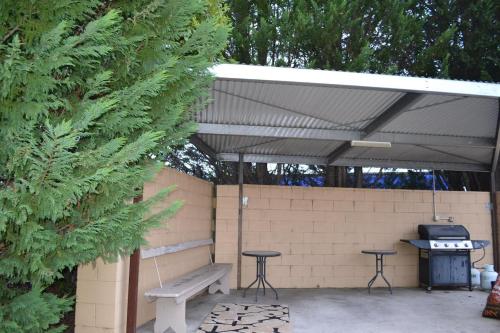 a picnic shelter with a bench and a grill at Lithgow Motor Inn in Lithgow