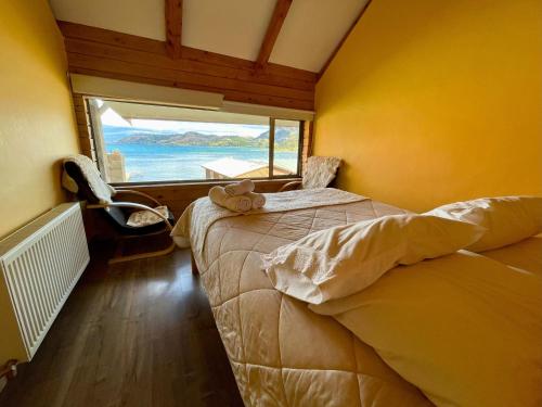 a bedroom with a bed and a large window at Cabañas Paraíso in Puerto Tranquilo