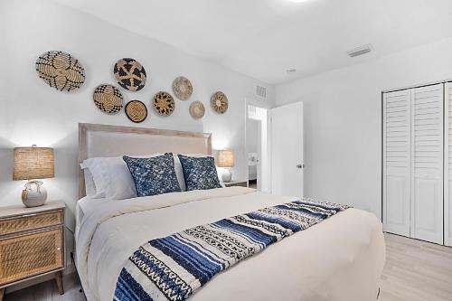 ein weißes Schlafzimmer mit einem großen Bett und Wandplatten in der Unterkunft Santorini Pool House Wilton Manors Walk to the Dr in Fort Lauderdale