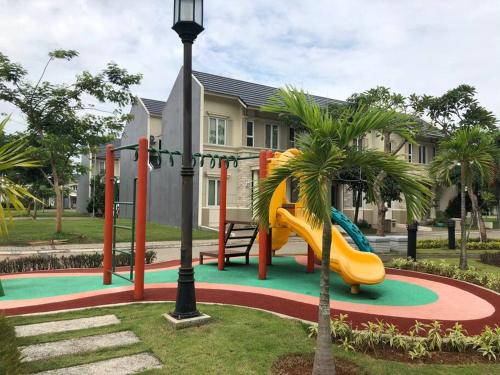 un parque infantil con un tobogán frente a una casa en akhemy homestay, en Tangerang