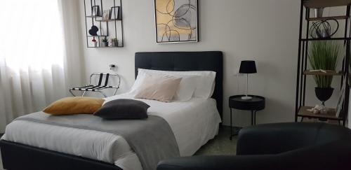 een slaapkamer met een bed met witte lakens en kussens bij Casa Lola in Cavallino-Treporti