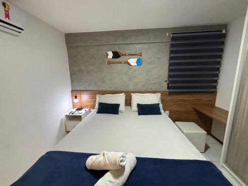 1 dormitorio con 1 cama blanca grande con sábanas azules en Apartamentos 250m da Orla -Edifício Nugali- Castelo B Temporada, en Maceió