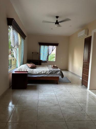 a bedroom with a bed and a large window at Departamento acogedor in Cunduacán