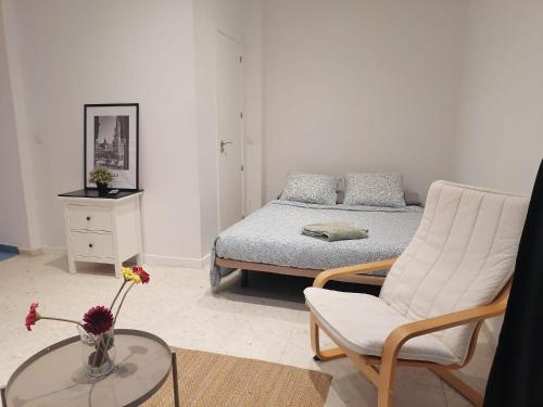 a bedroom with a bed and a chair and a table at Sevilla Central in Seville